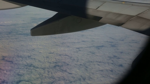从飞机窗口的机翼近距离向上看从左到右的云视频素材