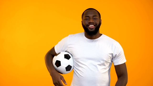 有魅力的美国黑人玩足球和显示拇指向上的手势视频素材
