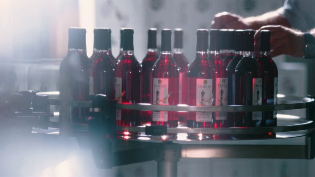 SLOMO。酒厂员工在旋转的显示器上检查红酒的质量。视频素材
