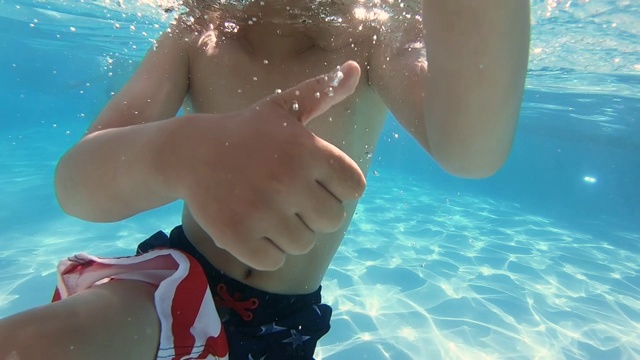 快乐的孩子在水下摆姿势和做手势视频素材