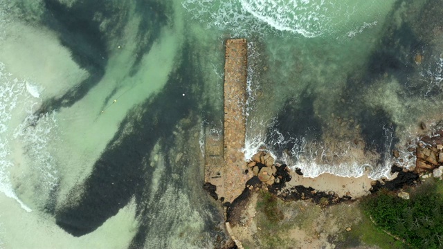 航拍的一个码头沐浴在透明的海洋，撒丁岛，意大利。视频下载