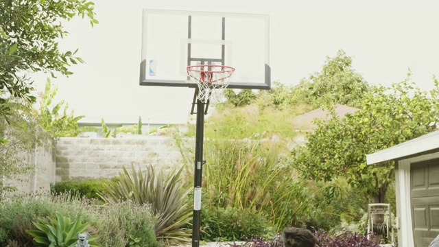 爸爸和儿子在家打篮球的慢动作录像视频素材
