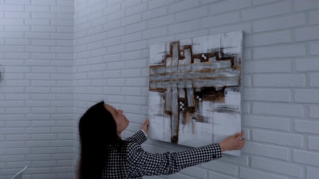 一个画廊经理准备当代艺术展览的艺术品的侧视图，女商人在工作视频下载
