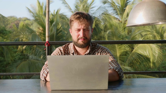 长着胡子的帅哥在户外用笔记本电脑打字视频素材