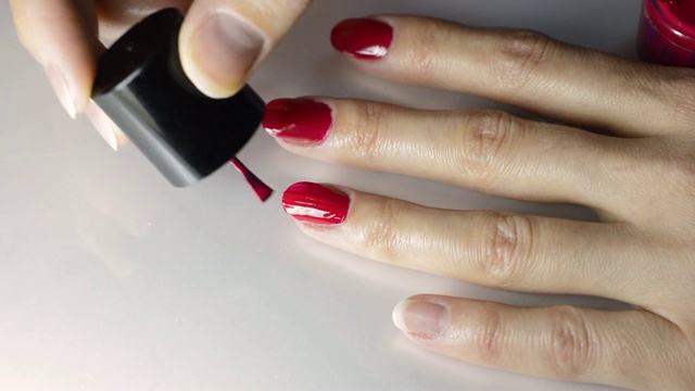 女孩用红色指甲油涂指甲视频下载