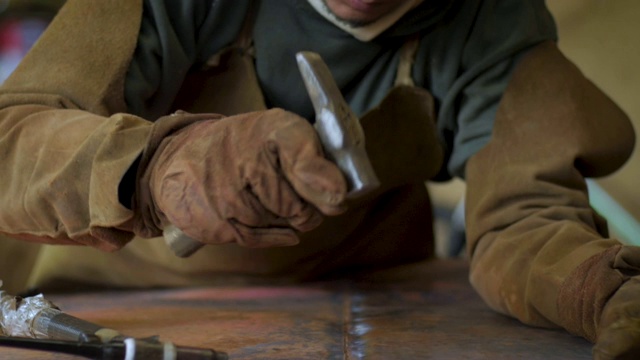熟练的工匠将铜焊接后锤打在一起视频下载