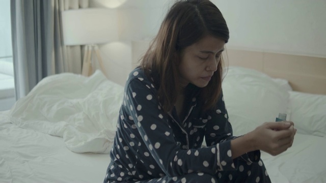 年轻女子在家里的床上使用哮喘吸入器视频下载