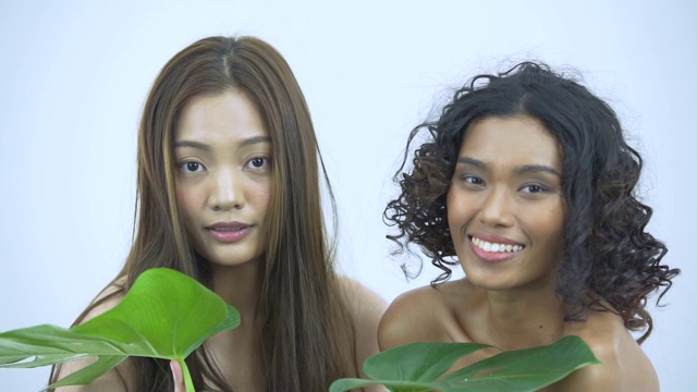 美丽的亚洲年轻的模特女人的脸和皮肤与植物视频素材