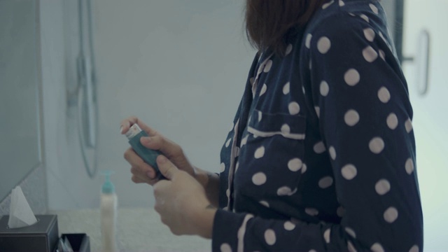 年轻女子在卫生间使用哮喘吸入器视频下载
