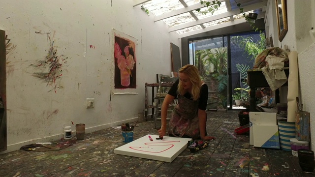 一个成熟的女人在家的画室里画画。视频下载