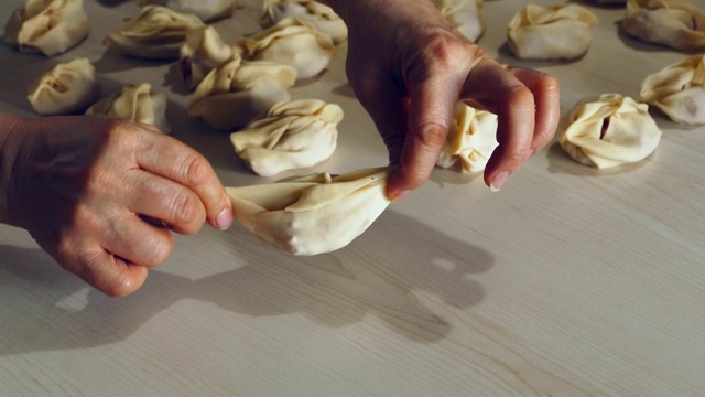 一个女人正在准备做意大利饺子的面团，用肉做意大利饺子，做意大利饺子面团，糕点，视频素材