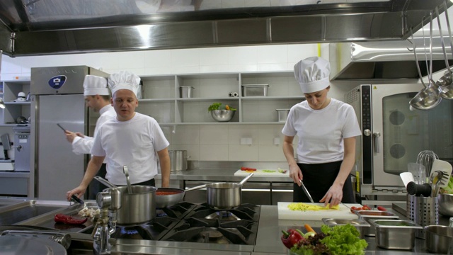 忙碌的厨师和厨房厨师咨询平板电脑视频素材