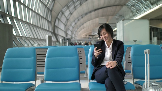 亚洲女商人在机场终端使用手机视频素材