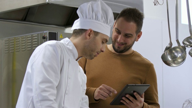 厨师烹饪和经理与平板电脑咨询视频素材