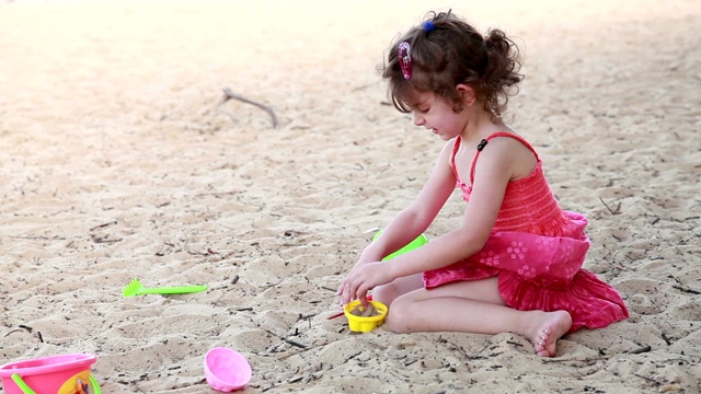 小女孩在沙滩上玩沙子视频素材