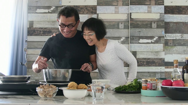 一个中国男人和一个女人在厨房做饭视频素材