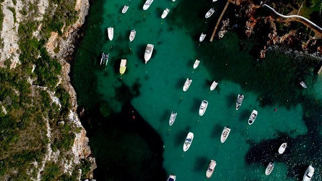 无人机俯瞰西班牙米诺卡湾的船只。美丽的海滩和地中海碧绿的海水。夏日美景尽收眼底。视频素材