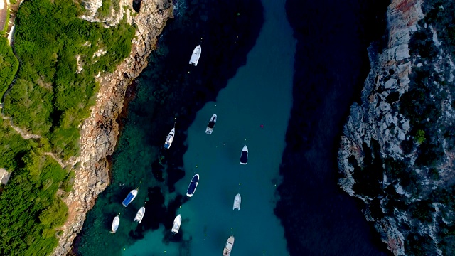 西班牙米诺卡湾船只的鸟瞰图。美丽的海滩和地中海碧绿的海水。夏日美景尽收眼底。视频素材