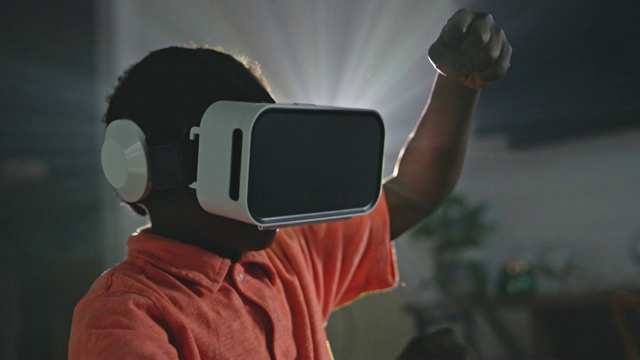 非裔美国男孩在玩虚拟现实电子游戏，用手模仿方向盘。视频素材