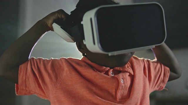 年轻的非裔美国男孩戴上虚拟现实头盔，环顾四周。视频素材