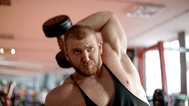 年轻的白人健美运动员在健身房里训练三头肌视频素材