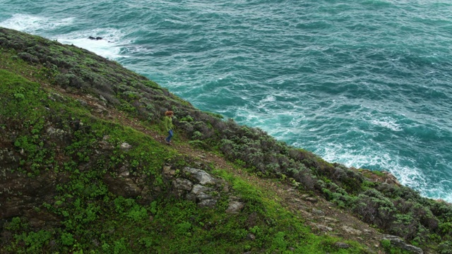 女人走下山脊在大陆地上空的海洋视频素材