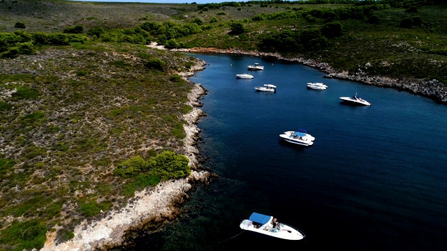 西班牙米诺卡湾的船只全景。美丽的海滩和地中海的蓝色海水。在陆地上，只有岩石和草的自然。视频素材
