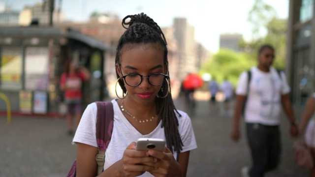 非洲裔拉丁年轻女子在城市使用智能手机肖像视频下载