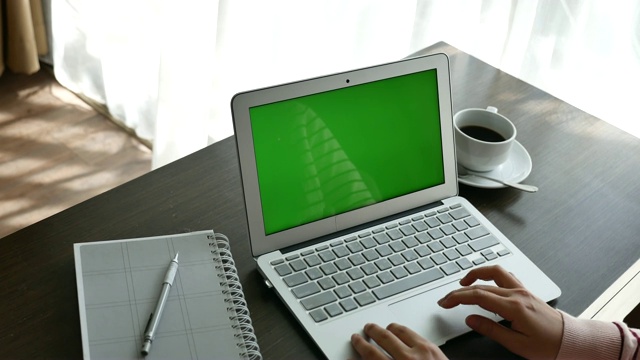 使用绿屏笔记本电脑的女人视频素材