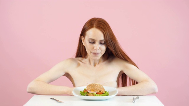 快乐瘦女孩打破了饮食，吃了一个汉堡。违反了饮食。厌食症视频素材