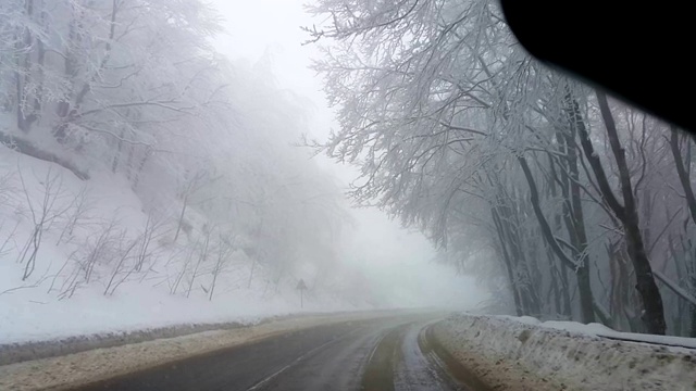 POV驾驶在积雪覆盖的道路上，在白天，大雪暴风雪视频素材