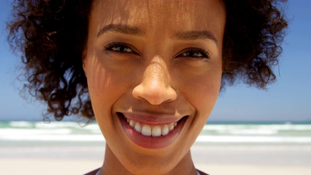 女人在一个阳光明媚的日子在海滩微笑的特写4k视频素材