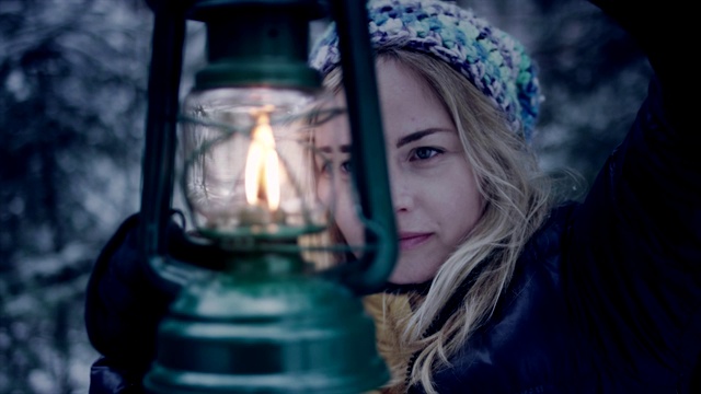 美丽的女人提着灯笼走在森林里。冬季仙境视频素材