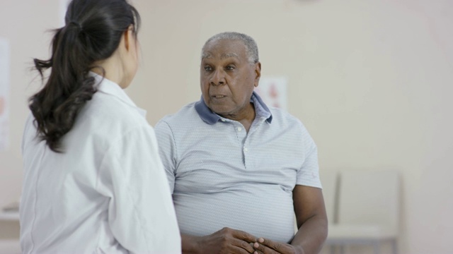 一名少数民族高级男子在与一名女医生预约时交谈视频素材