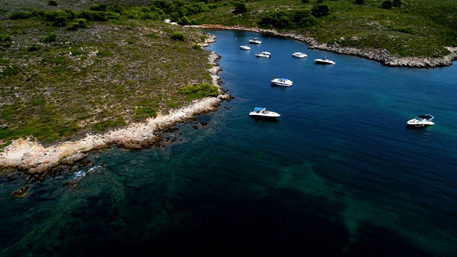 西班牙米诺卡湾的船只全景。美丽的海滩和地中海的蓝色海水。在陆地上，只有岩石和草的自然。视频素材