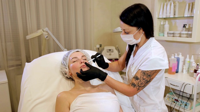 美容师用一支白色铅笔在病人的脸上画出轮廓。视频素材