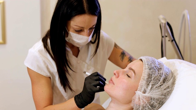 美容师用一支白色铅笔在病人的脸上画出轮廓。视频素材