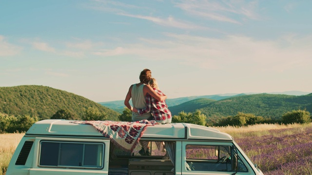 一对情侣坐在车顶上接吻视频素材