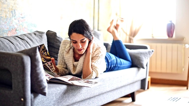 一个土耳其女人坐在沙发上看杂志视频下载
