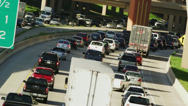 长镜头拍摄的州际交通拥堵，汽车，卡车，半行驶远离相机。视频下载