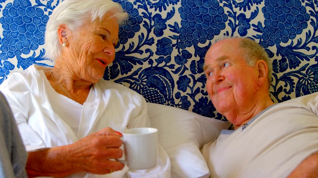 正面视图的白人老年夫妇相互互动在床上舒适的家4k视频下载