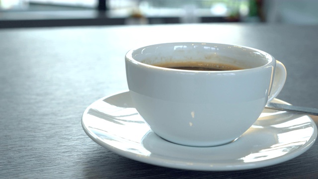 特写的热咖啡杯在商店的木桌上在早上视频素材