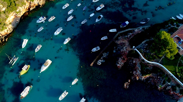 无人机俯瞰西班牙米诺卡湾的船只。美丽的海滩和地中海碧绿的海水。夏日美景尽收眼底。视频素材