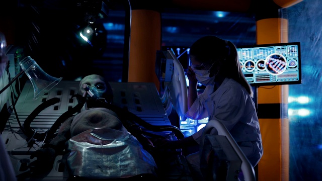 实验室技术员正在观察外星人。机器人躺在手术室的传感器下面。一个陌生人的呼吸。视频素材