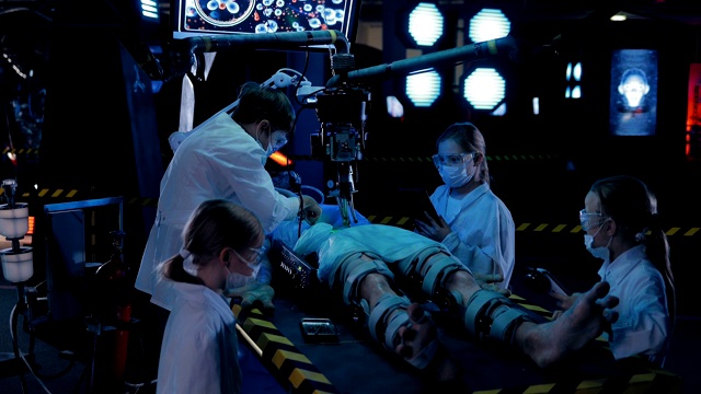 科学家们正在研究外星人。人形躺在手术台上，与仪器和传感器相连。视频素材