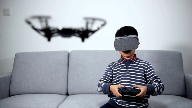 聪明的小男孩在玩无人机和VR视频素材