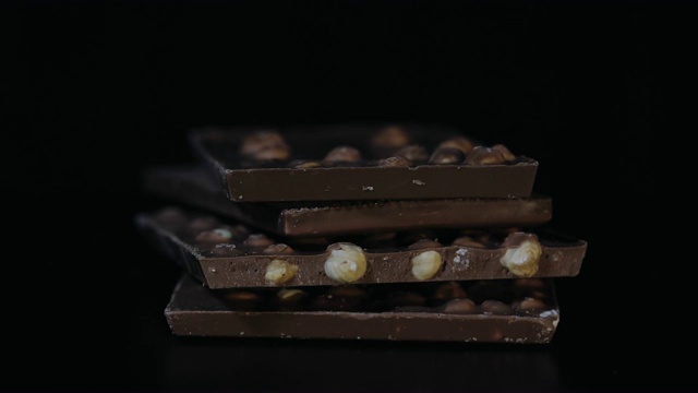 黑巧克力块与坚果细节缓慢的特写倾斜。用巧克力棒做的透视视频下载