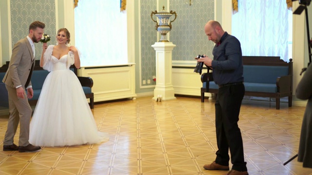 后台婚纱摄影-专业摄影师在别致的房间里为新婚夫妇拍照视频素材