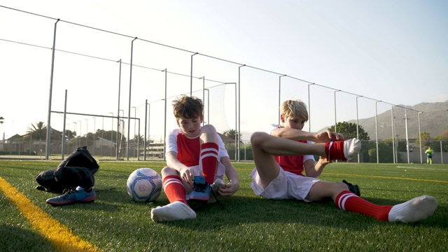 男孩们在比赛前穿上他们的足球鞋视频素材