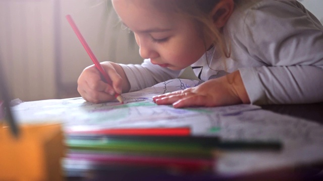 一个小女孩在客厅的桌子上选择铅笔和做作业-股票视频视频下载